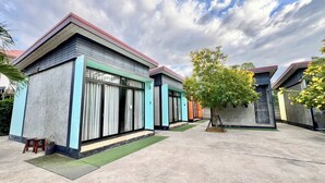 A modern building with a flat roof and large windows. There is a tree in the center of the courtyard. - Ban Ton Resort (Udon Thani)