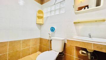 A bathroom with a toilet, sink, and a mirror.