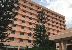 A multi-story hotel with balconies and a clear sky.