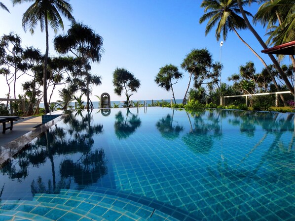 Alberca al aire libre, alberca infinita y camastros