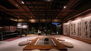 Um interior moderno com área de estar com tatame, um espaço para cerimônia do chá japonesa tradicional e caligrafia nas paredes.