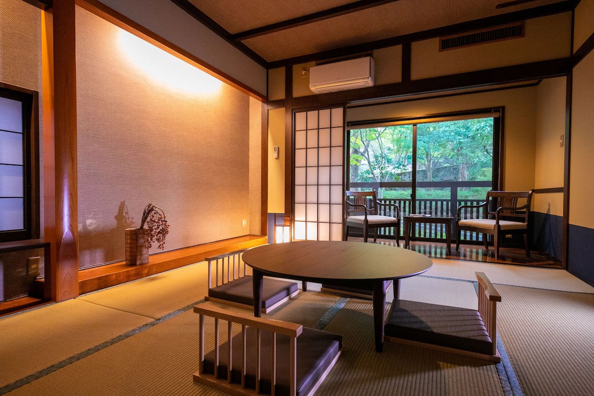 Ein traditioneller japanischer Raum mit Tatami-Bodenbelag, einem niedrigen Tisch und Shoji-Schirmwänden.