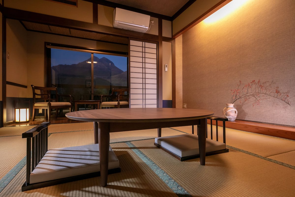 Ein traditioneller japanischer Raum mit Tatami-Boden, einem niedrigen Tisch und einer verschiebbaren Shoji-Schirmwand.