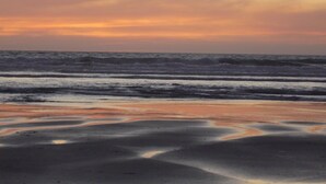 Una platja amb ones i un capvespre.