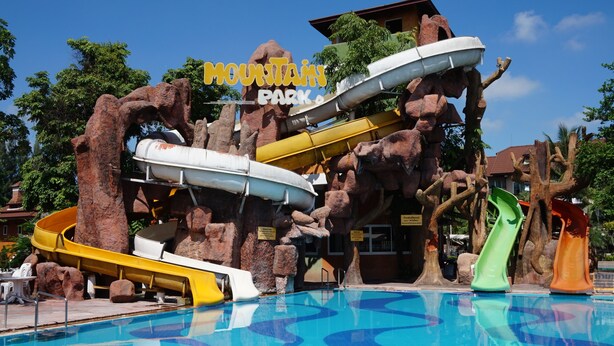 Een waterpark met meerdere glijbanen en een zwembad.