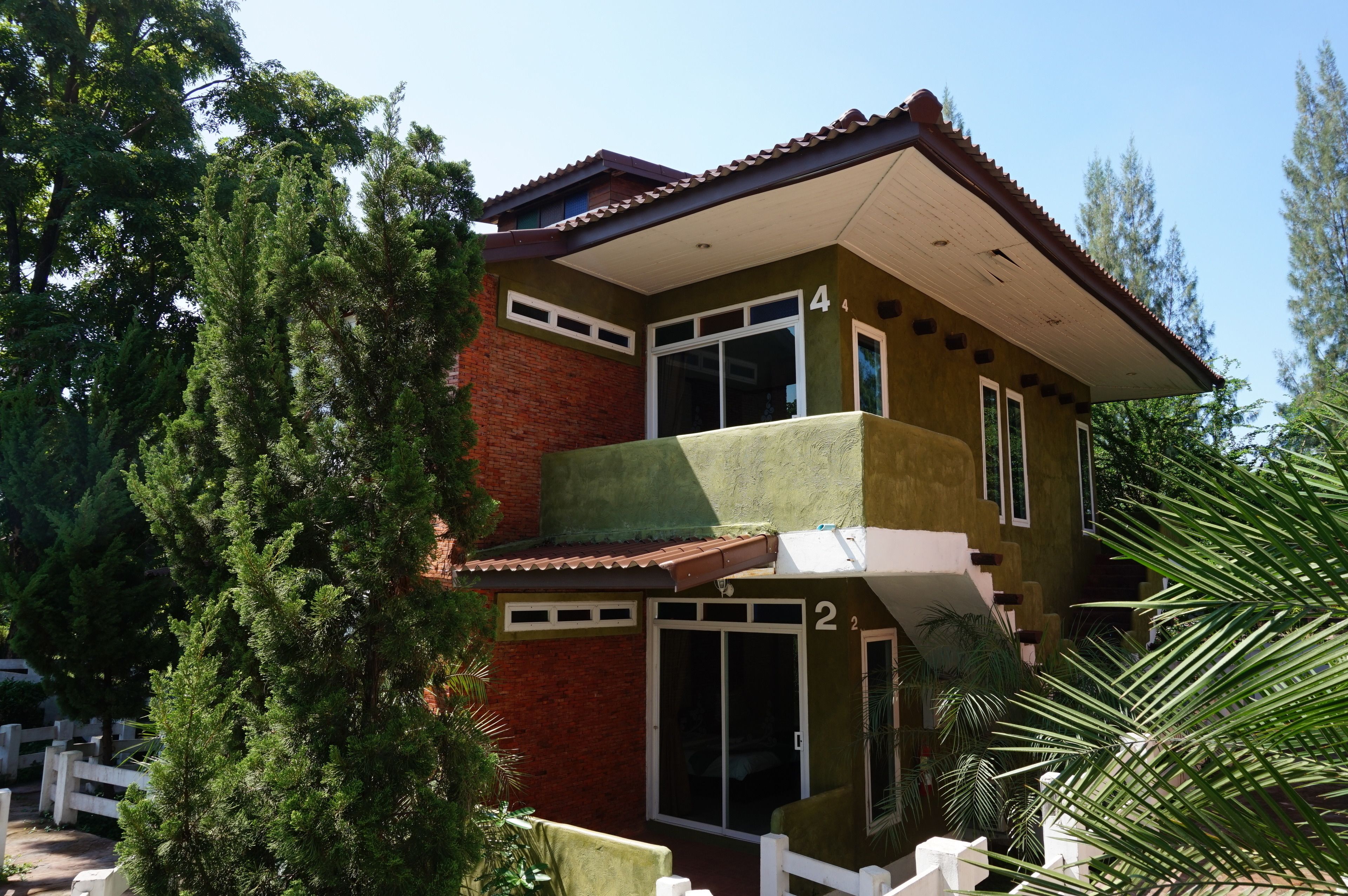 A two-story building with a balcony on the second floor, a brick facade, and a number '4' on the upper level.
