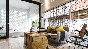 Um interior moderno com sofá, baú de madeira e ladrilhos estampados.