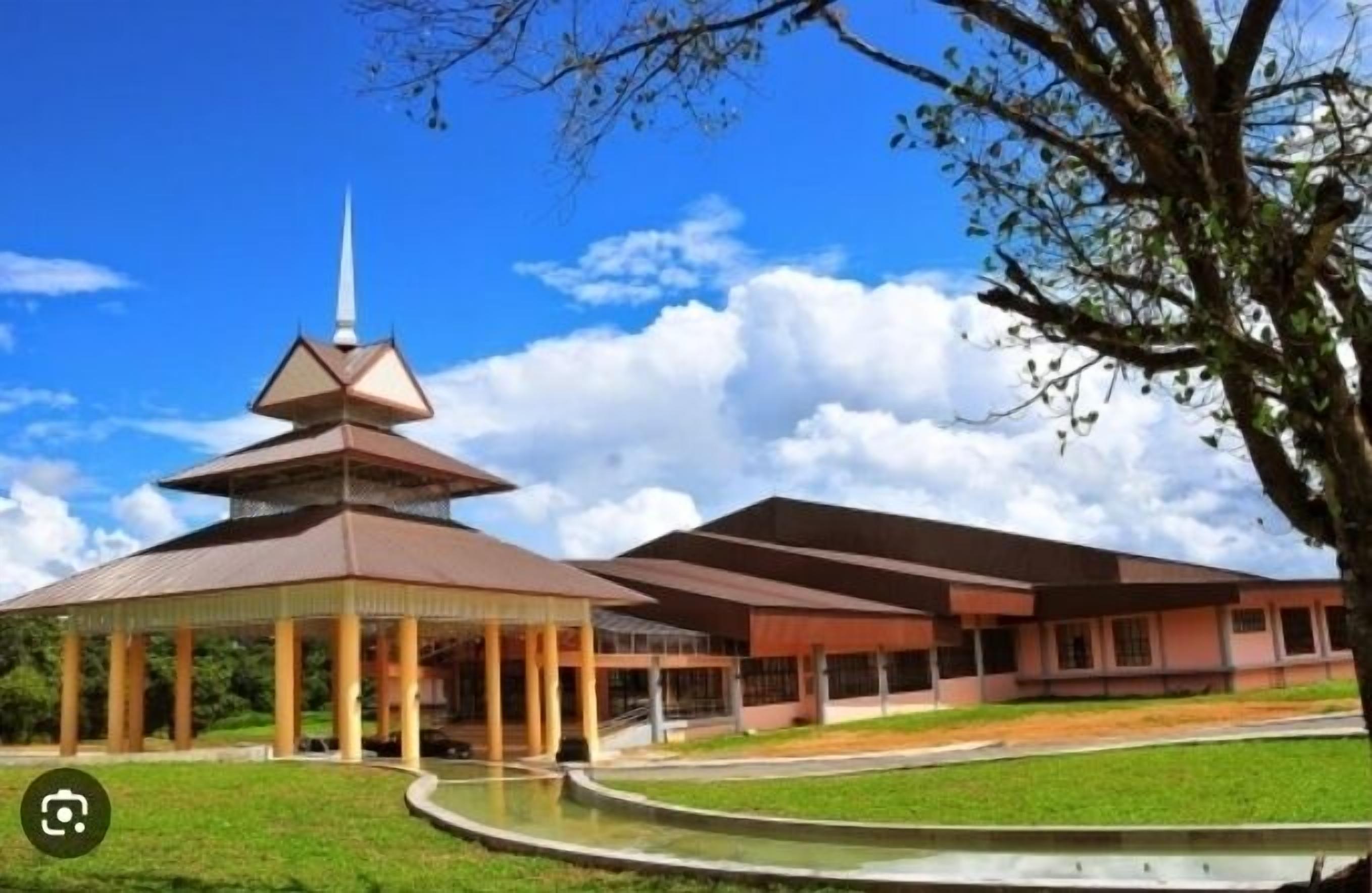 A building with a central tower and a covered pavilion.