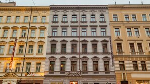 A hotel with a classic facade, multiple windows, and a sign indicating it is a hotel. - Vinohradský dům (Prague)