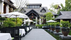 Un restaurante con terraza, una fuente de agua y arquitectura tradicional.