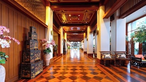 Vestíbulo de hotel con suelo a cuadros, paneles de madera y decoración tradicional.