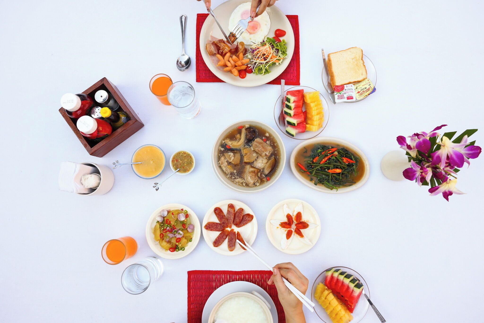 Una mesa con diferentes platos, bebidas y acompañamientos.
