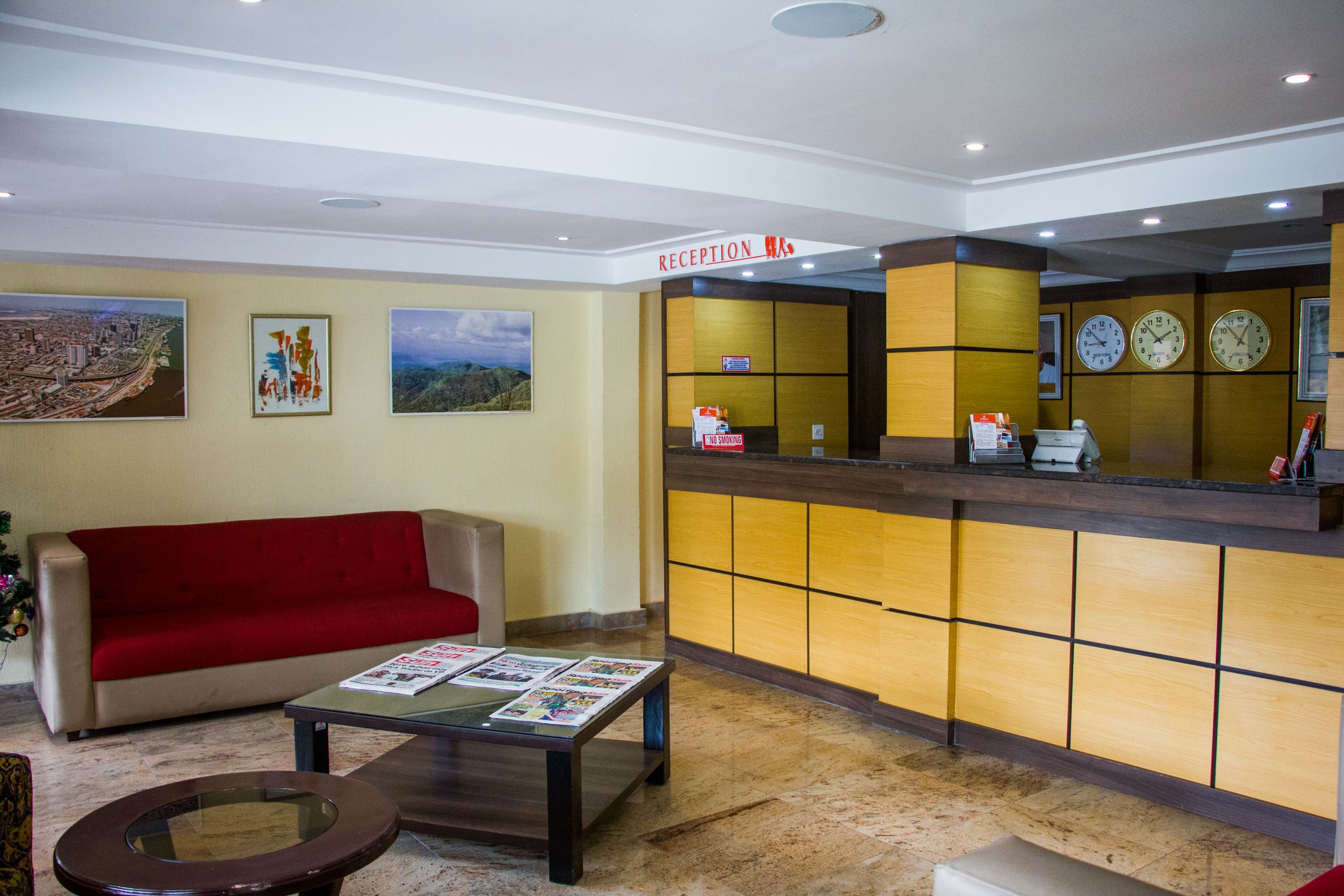 A reception area with a red sofa, a reception desk, and a coffee machine.