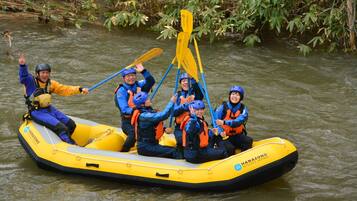 A group of people in a yellow inflatable raft on a river.