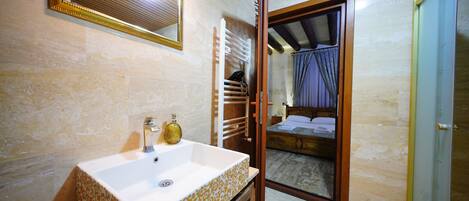 A bathroom with a sink, mirror, and wooden cabinets.