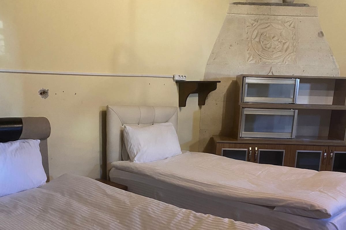 Habitación de hotel con dos camas, un armario de madera y un adorno en la pared.
