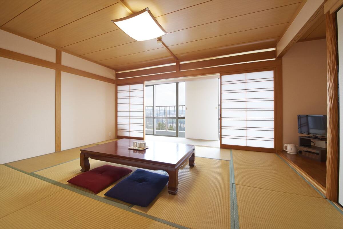 A traditional Japanese room with tatami flooring, a low wooden table, and sliding doors.