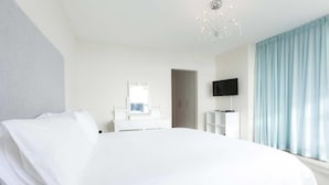 A modern hotel room with a large bed, a TV, a wardrobe, and a chandelier. - Vue Devant (Cape Town)