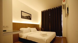 A hotel room with a bed, a chair, a desk, and a wall-mounted air conditioner. - Place2Stay Business Hotel - Waterfront (Kuching)