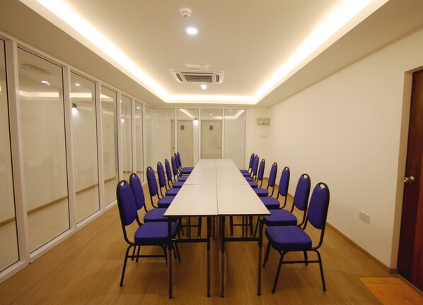 A conference room with a long table and chairs, glass partitions, and ceiling lights. - Place2Stay Business Hotel - Waterfront (Kuching)