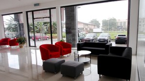 A lobby with red and black chairs, a black sofa, and a small table. - Place2Stay Business Hotel - Waterfront (Kuching)