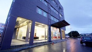 A modern building with large windows and a sign indicating it is a business center. - Place2Stay Business Hotel - Waterfront (Kuching)