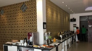 A buffet setup with a coffee machine, various food items, and a beverage dispenser. - Perfect Hotel (Mandalay)