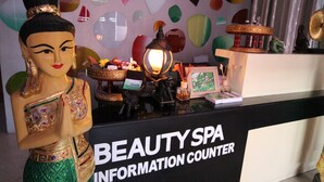 A beauty spa information counter with a decorative statue, a lamp, and various spa-related items. - Perfect Hotel (Mandalay)