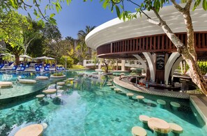 Un espace piscine avec une eau cristalline, des chaises longues bleues et un coin bar agrémenté d’une enseigne indiquant : « Une bonne idée : prendre un café ».