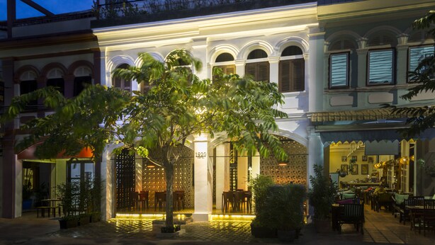Un edificio tradicional con un área de estar al aire libre techada y un restaurante en su interior.