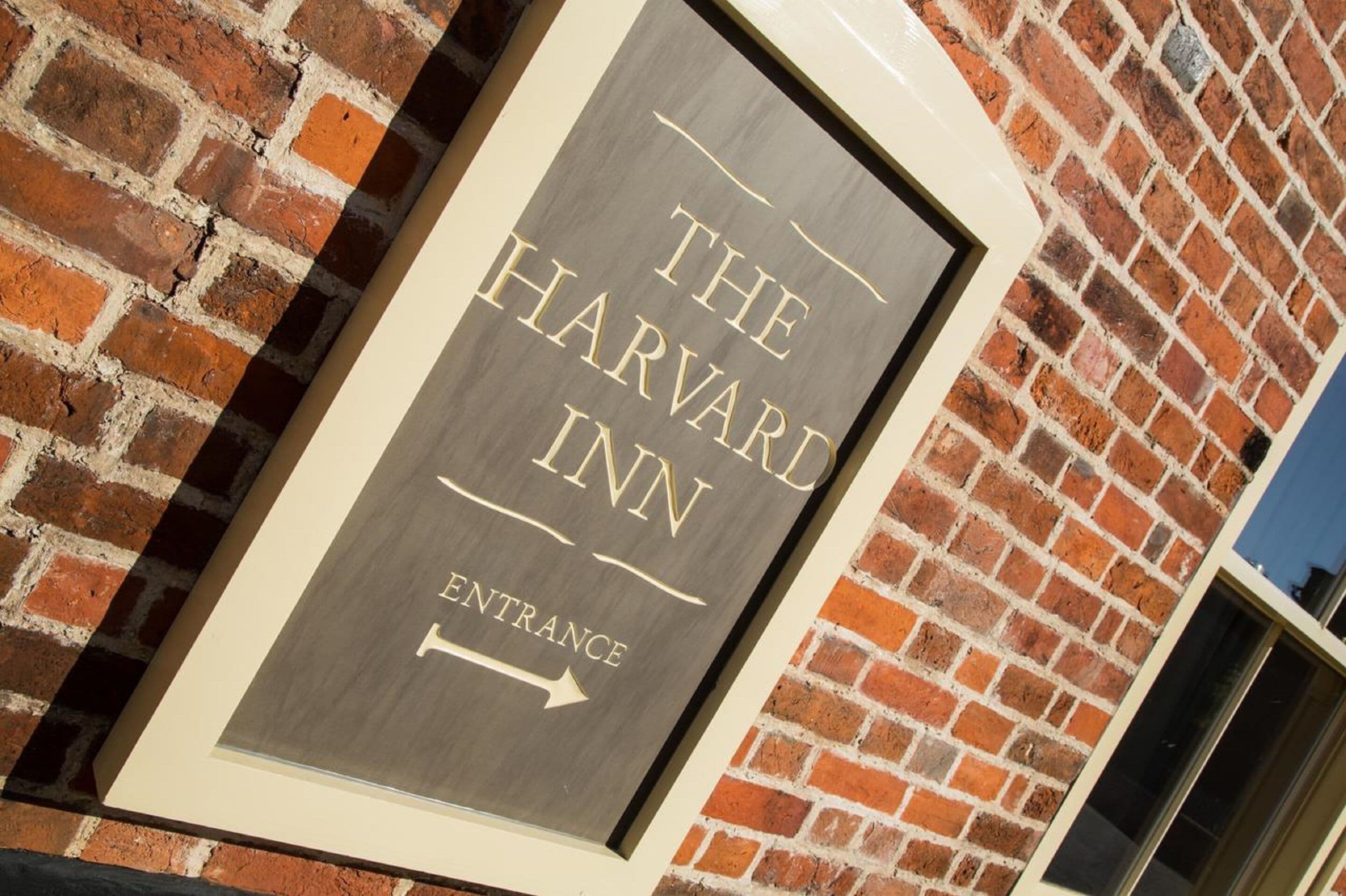 Placa do The Harvard Inn com uma seta apontando para a entrada.