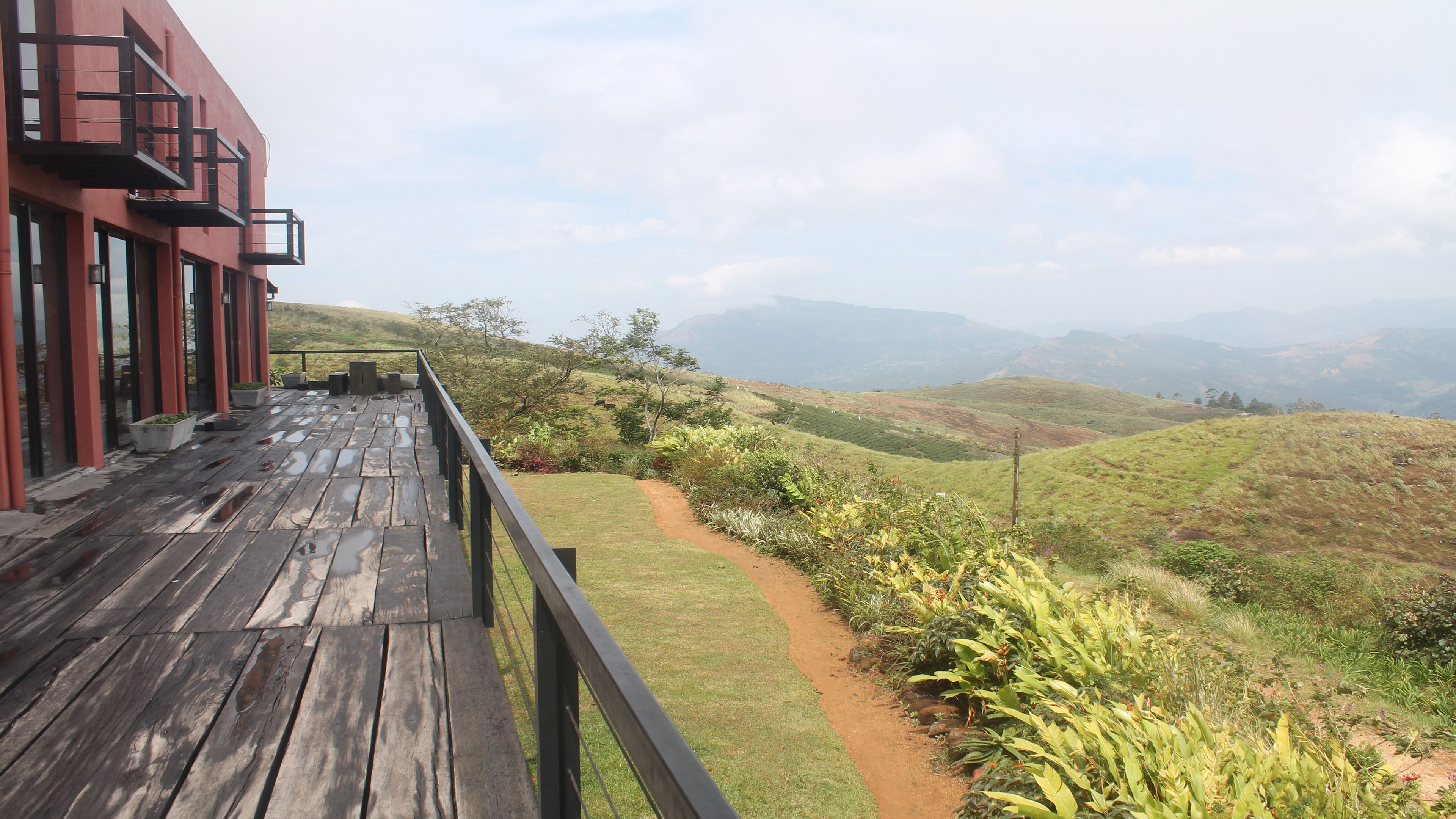 A wooden deck with a view of a hilly landscape.