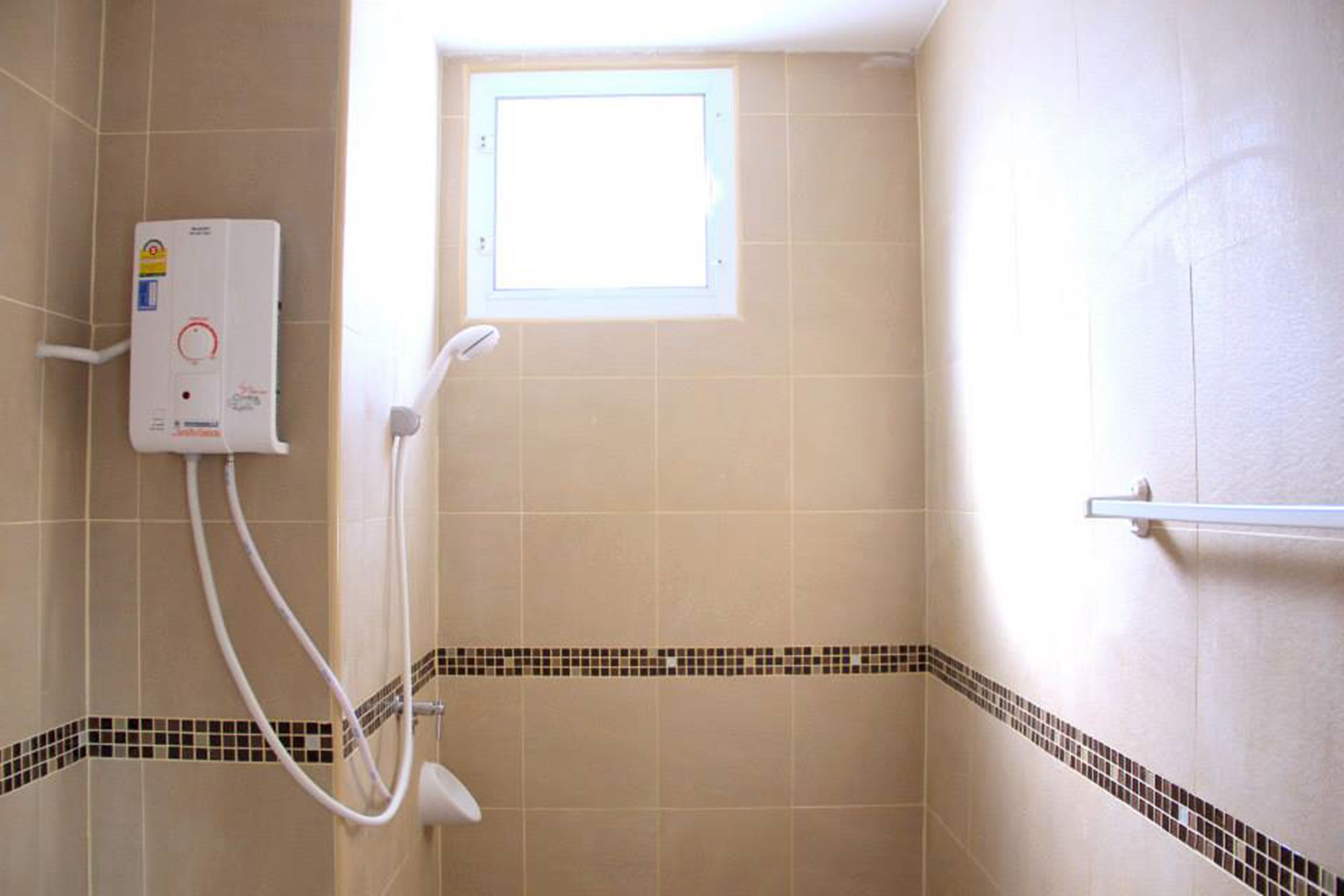 Une salle de bain avec une douche, une fenêtre et un porte-serviettes.