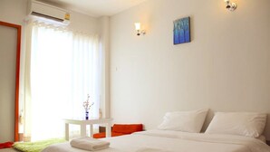 Habitación de hotel con cama, una mesita, una silla y un cuadro en la pared.