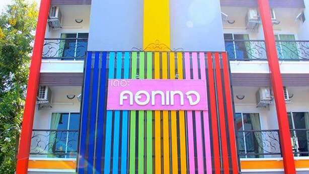 Un edificio de varios pisos con fachada colorida, balcones y un letrero que dice 'The Cottage'.
