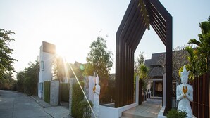 Un edificio moderno con un diseño arquitectónico único, que incluye un arco pronunciado y estatuas.