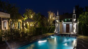 Relax by the pool surrounded by a gazebo and lounge chairs.