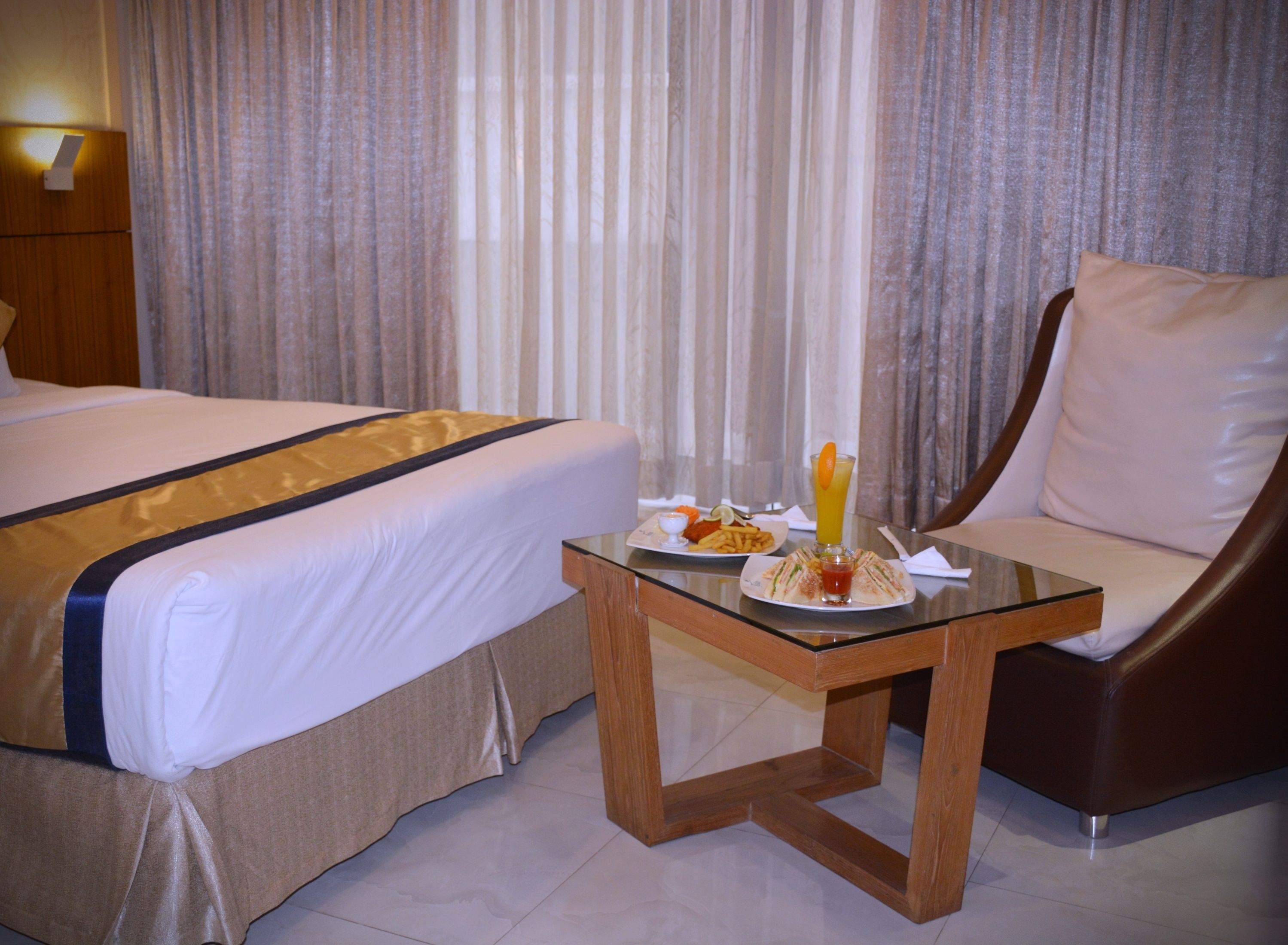 Habitación de hotel con dos camas, una mesa de comedor y una comida, y una silla.