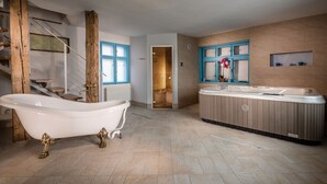 A spacious bathroom with a freestanding bathtub, a hot tub, and a shower area. - Apartments Ceresnovy Sad (Mengusovce)