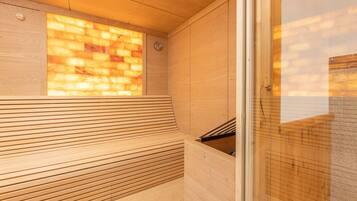 A sauna with wooden benches and a glass wall.