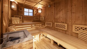 A wooden sauna with benches and a stone bench. - Hotel Augarten (Neustift Im Stubaital)