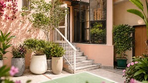 A building with a staircase, potted plants, and a green outdoor area. - Bella Rose Apart Hotel (Alanya)
