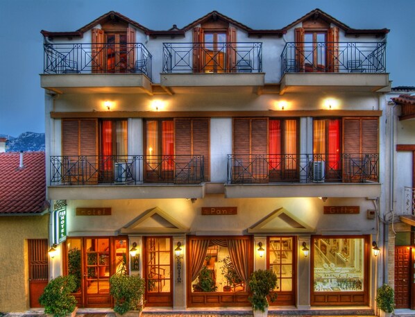 A hotel with multiple balconies, large windows with shutters, and a sign indicating it is a Pan Hotel.
