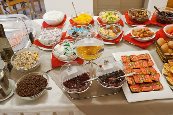 A buffet table with various food items and condiments.
