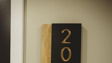 A wall-mounted number plate with the numbers 203.