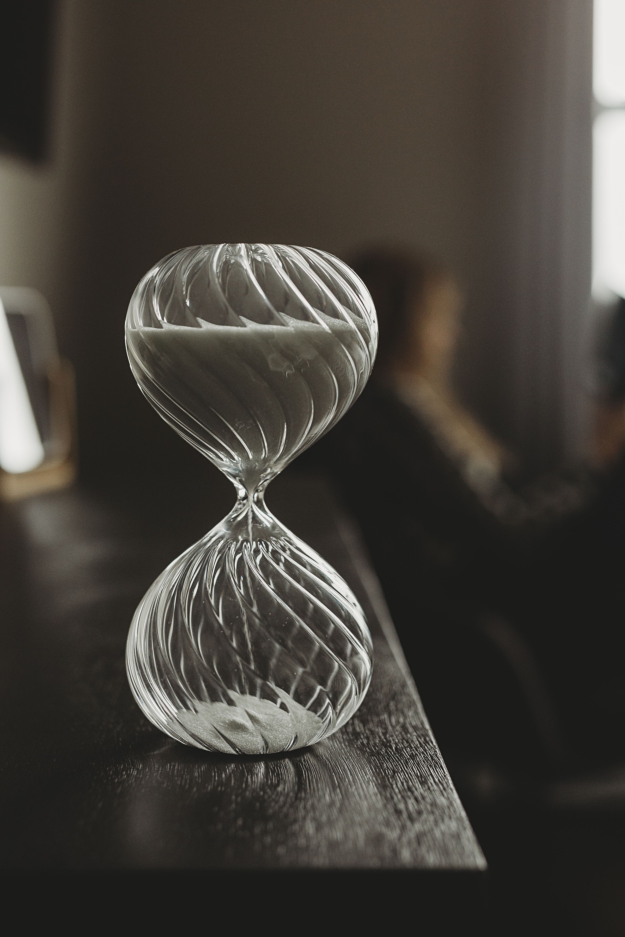 Eine klare Sanduhr auf einer Holzoberfläche.
