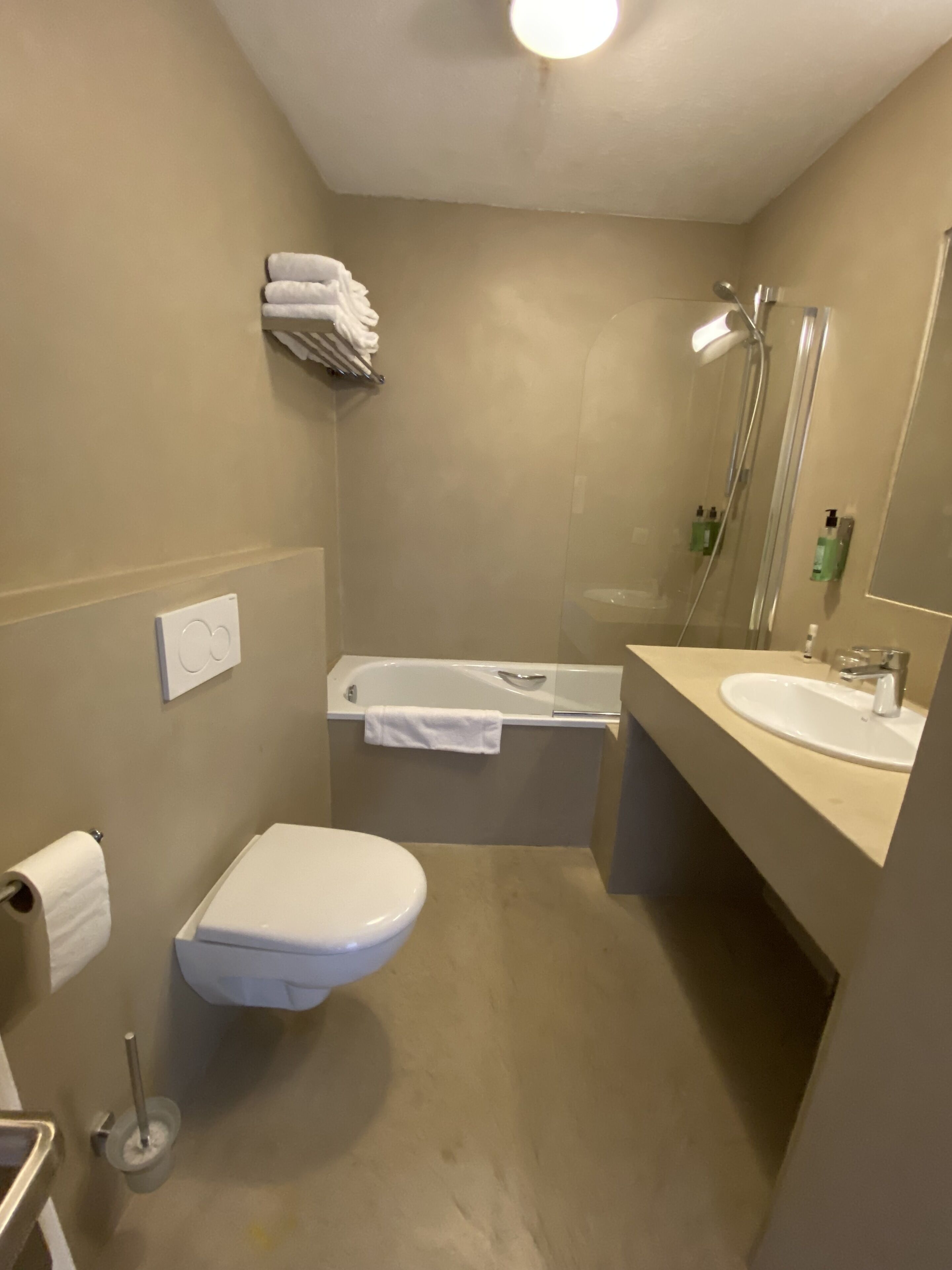Une petite salle de bain comprenant des toilettes, un lavabo et une baignoire.