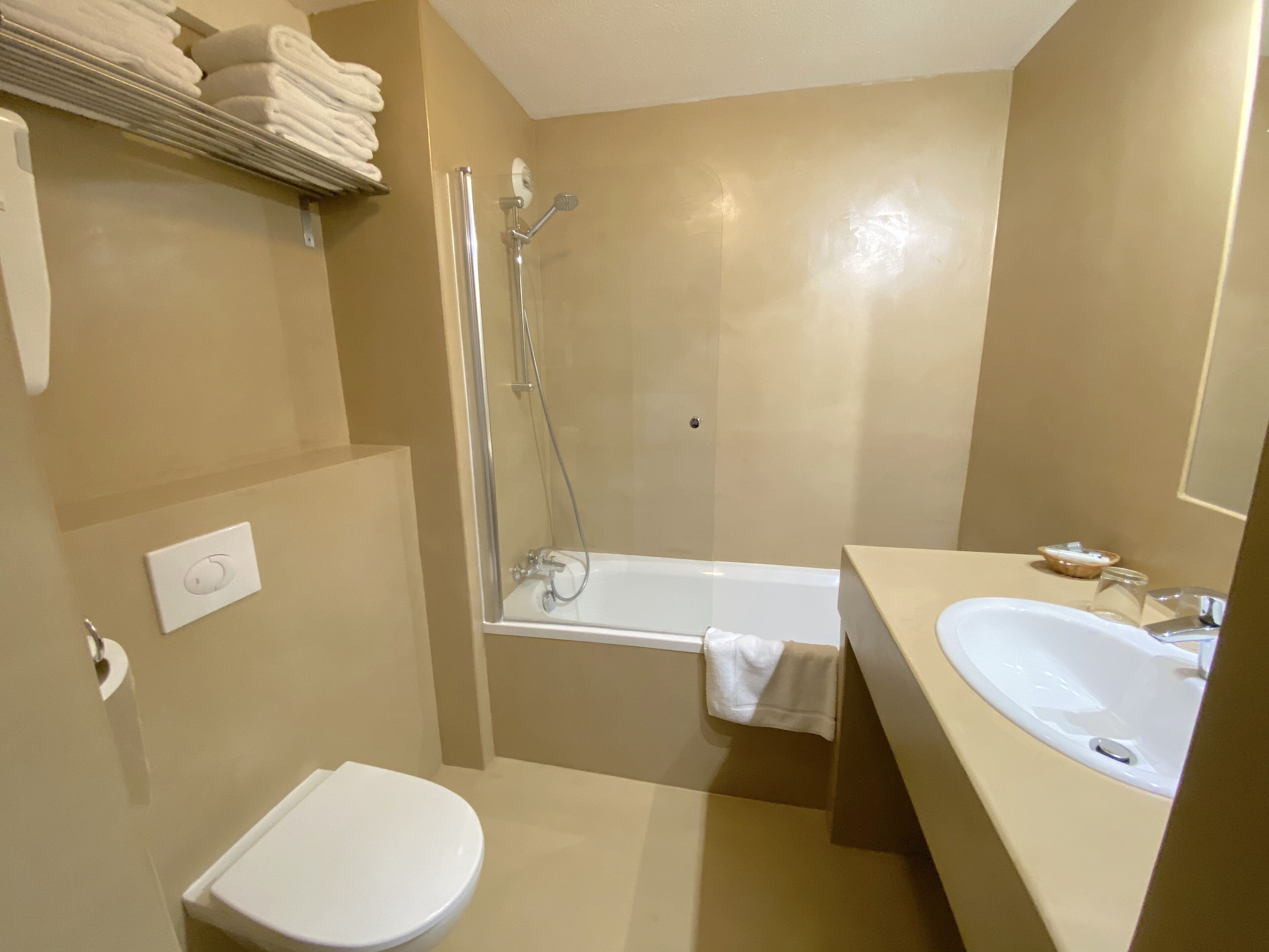 Une salle de bain avec des toilettes, une douche et un lavabo.