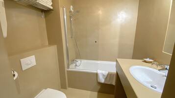 Une salle de bain avec des toilettes, une douche et un lavabo.