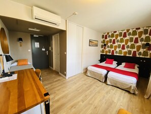 Eenvoudige driepersoonskamer | Luxe beddengoed, een kluis op de kamer, een bureau, een laptopwerkplek